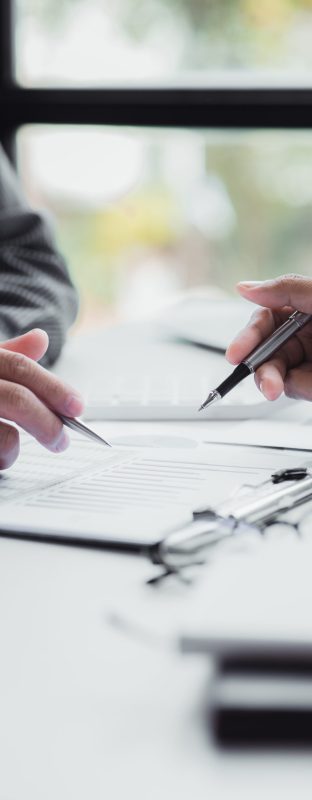Two businessmen pointed to the material for the meeting, working together to plan to develop and solve common business problems. Concept of business management for growth and quality.